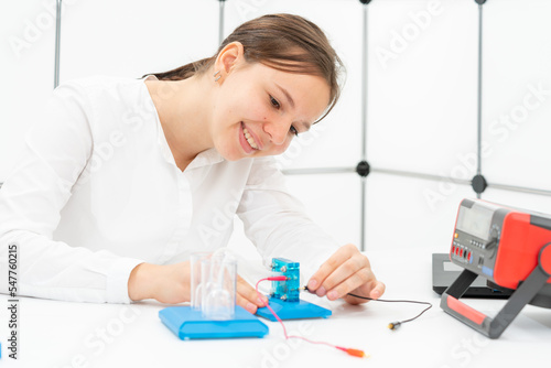 Photography schoolgirl experimenting with a hydrogen fuel cell at renewable energy lessons