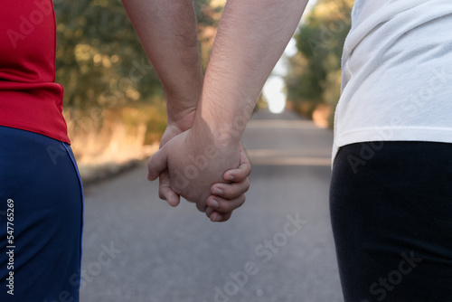 sporty couple holding hands walk together