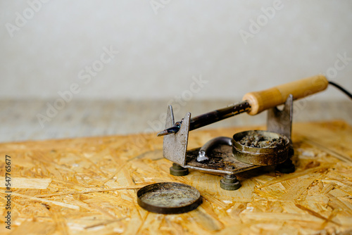 soldering iron with a wooden handle with solder and rosin on the board
