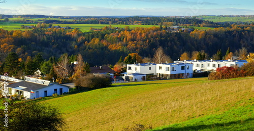 Schönes Neubaugebiet mit modernen Häusern an  Wiese im Schwarzwald unter blauem Himmel 	