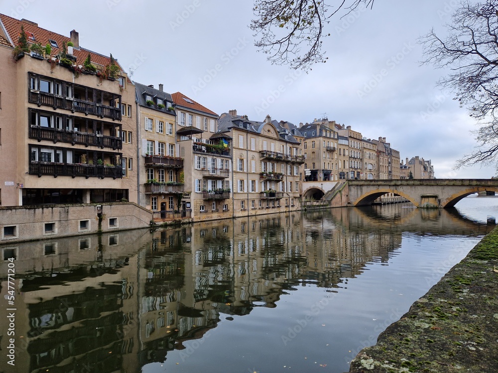 Reflection in river Meuse of old houses in Metz, seen from Ile de Comédie, Lorraine