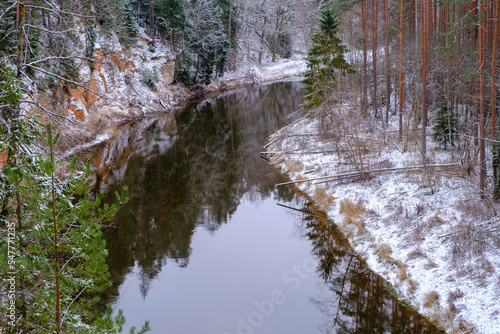 The river Salaca is meandered by high sandstone cliffs. Skanaiskalns nature park. November is the first snow in Mazsalaca in Latvia. photo
