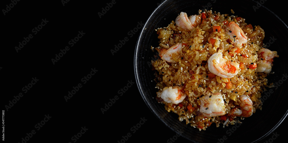 Fried rice with shrimp and sesame, on a dark background Fried rice with shrimp and sesame, on a dark background