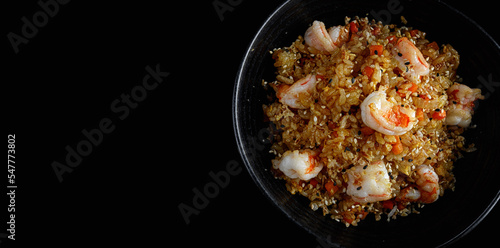 Fried rice with shrimp and sesame, on a dark background