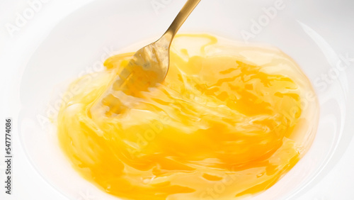 Foto Stirring eggs with fork in white plate, close up