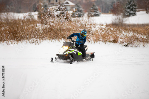 Boy riding snowmobile in the winter time