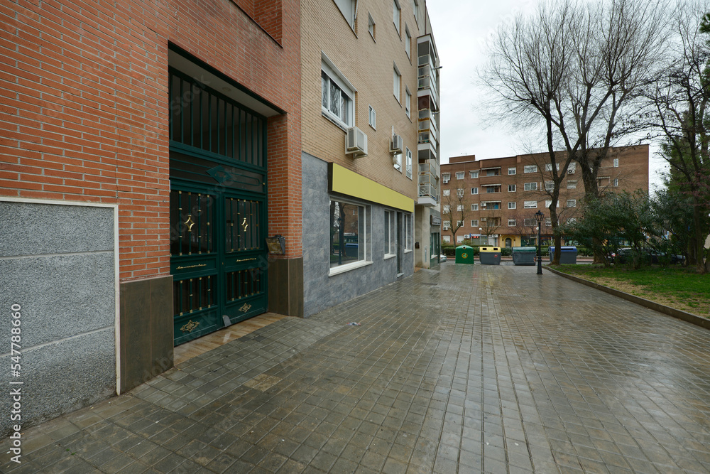 Facades of residential buildings with access from an external portal on a rainy day