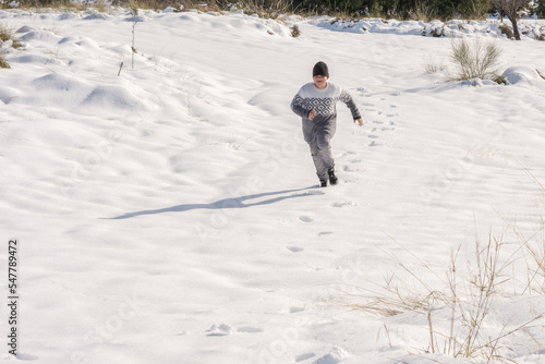 child running in the snow on a sunny day © CarloslVives