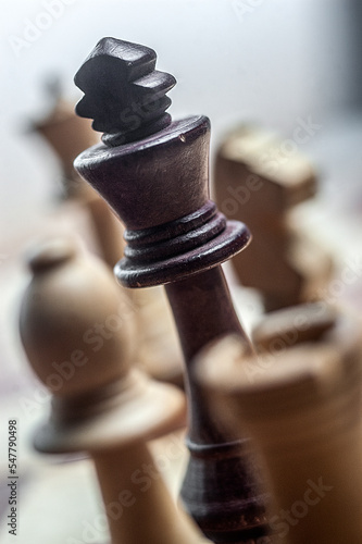 black chess king surrounded by white pieces. photo