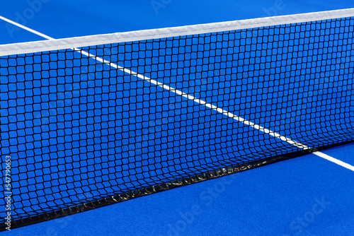Paddle tennis and tennis net on blue court. Tennis competion concept. Horizontal sport poster, greeting cards, headers, website © Augustas Cetkauskas
