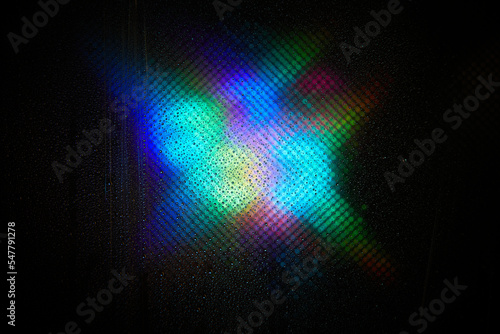 Water drop background. Image refraction of light. Defocused color iridescent radiance texture on a dark background.