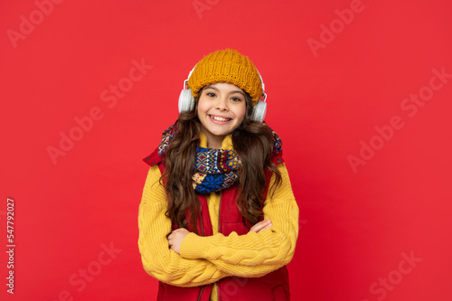 happy child in hat listening music in headphones, education