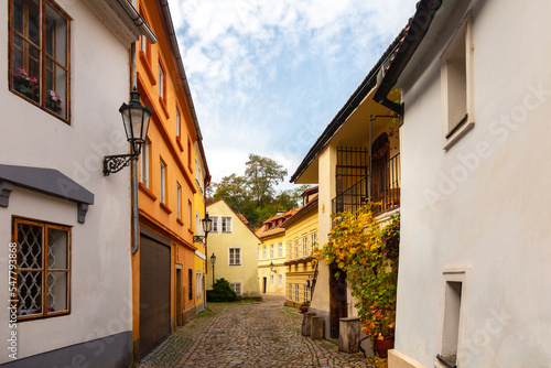 Fototapeta Naklejka Na Ścianę i Meble -  Tourism in Europe. View on old streets of Prague in the morning, city center, Czech Republic, European travel. Typical old buildings with red tile roofs in Prague in foggy day. 