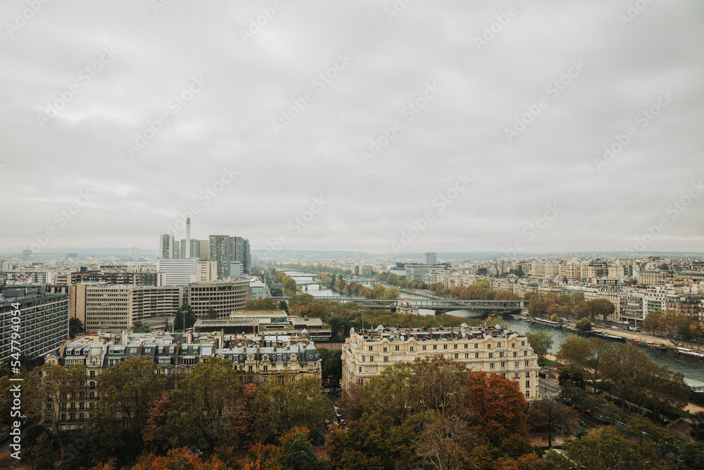 Top view of a European country with lots of green trees and buildings. Image of Paris from above. French state in autumn