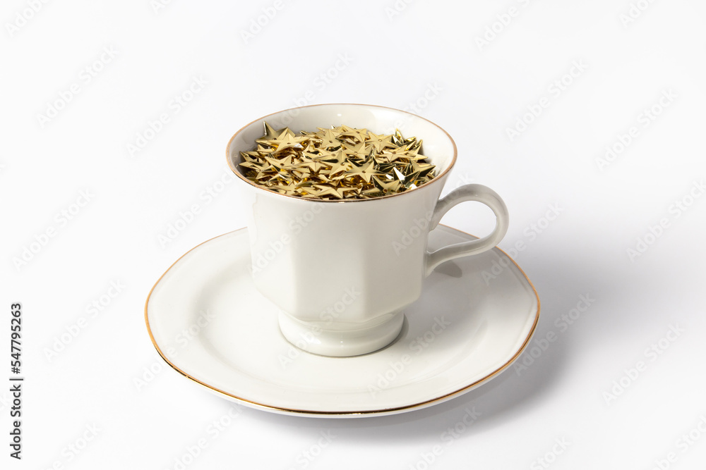 Teacups filled with gold stars on white background Teacups filled with gold stars on white background