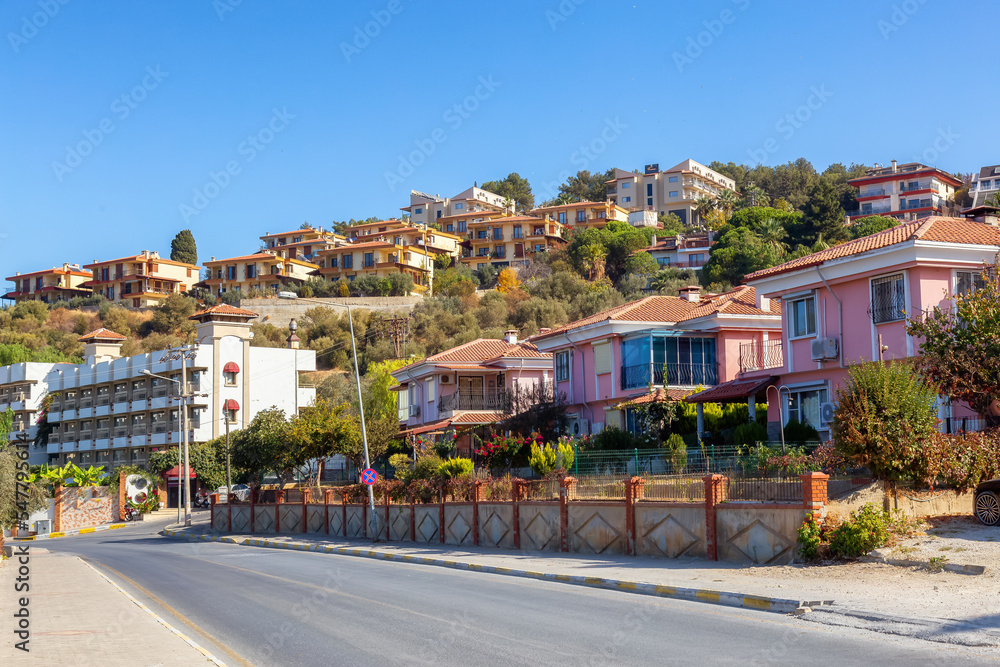 Fototapeta premium Street in Residential Neighborhood with homes and flowers. Kusadasi, Turkey. Sunny Morning.
