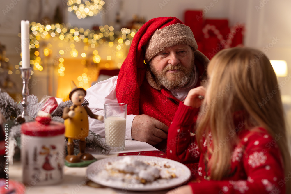 cheerful santa sits in the house at the table, christmas concept cheerful santa sits in the house at the table, christmas concept