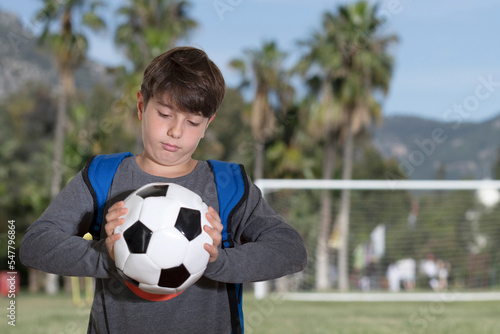 student kid with football at soccer field © izzetugutmen