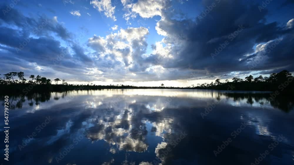 Timelapse of active sunset cloudscape over Pine Glades Lake in Everglades National Park, Florida reflected in still waters of lake 4K. Timelapse of active sunset cloudscape over Pine Glades Lake in Everglades National Park, Florida reflected in still waters of lake 4K.