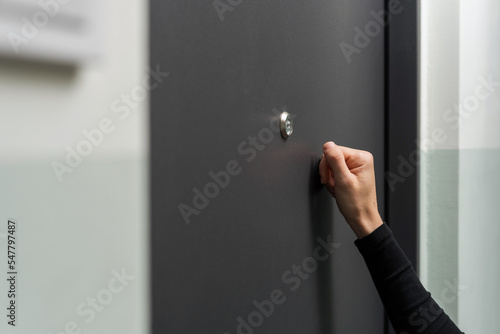 Woman hand knocking on the metal door photo