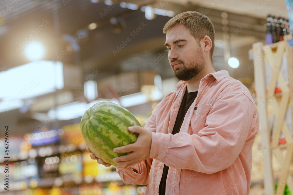Fototapeta premium the guy makes purchases in the supermarket, the concept of shopping