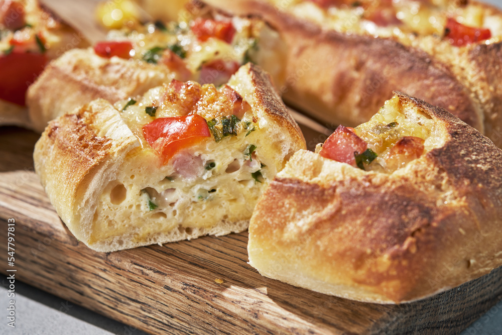 Bread boats stuffed with ham, egg, green onion and cheese for breakfast Bread boats stuffed with ham, egg, green onion and cheese for breakfast