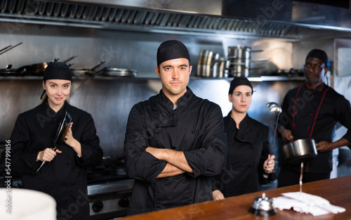 Portrait of team of cooks led by male chef in a restaurant kitchen