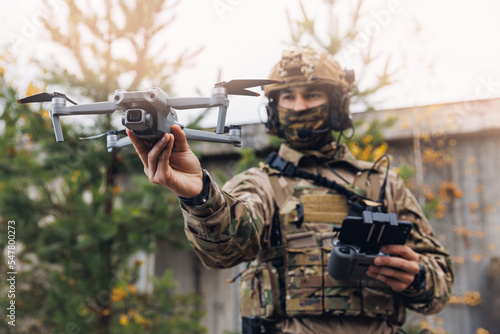 Modern army soldiers using aerial drone for artillery guidance and scouting view enemy positions in military operation