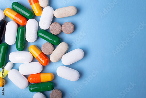 Top view of different pills on blue background,copy space for text.