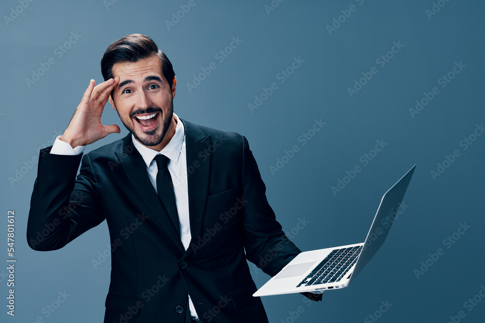 Man business looking at laptop and working online smiling with teeth surprised hand up via internet in business suit video call business talks win on blue background copy place Man business looking at laptop and working online smiling with teeth surprised hand up via internet in business suit video call business talks win on blue background copy place