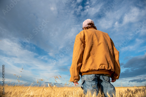Rancher woman surveying her wheat before harvest with an eye on the weather near Sidney, MT USA under clouding sky. © Gregory Borgstahl