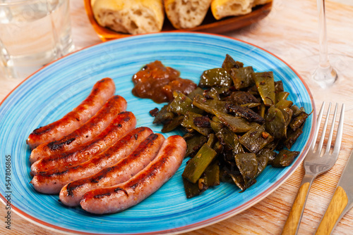 Tasty roasted sausages served with fried helda beans and savoury sauce.. photo