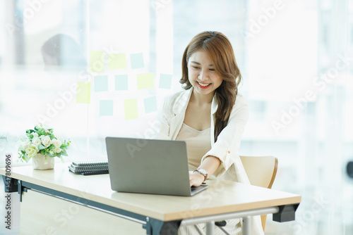 Free Download Smiling Cute asian woman working laptop happy for success. Attractive Happy female employee in the office or co-working space with copy space for label text. - GFXLoad