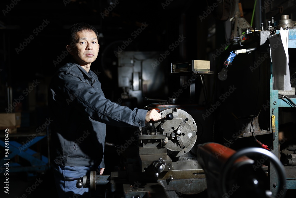 custom made wallpaper toronto digitalA craftsman poses in gray work clothes in front of a lathe at a local factory. Conceptual images of the essence of manufacturing, technical succession, and the challenge of high-precision machining.