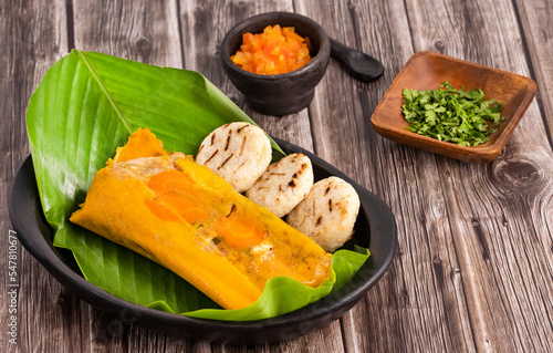 Traditional colombian tamales - Wrapped in green banana leaves photo