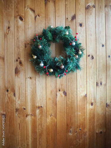 Christmas wreath on wooden wall, vertical Christmas background with copy space