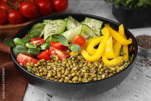 Bowl of salad with mung beans on white textured table, closeup