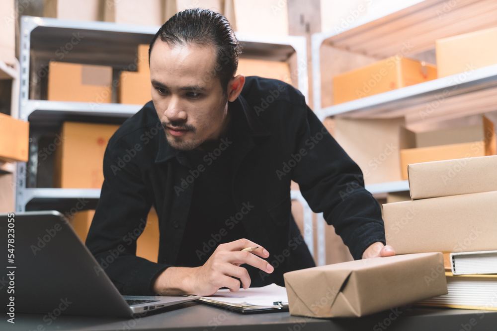 man watching and checking the online order for shipping the parcel to customer drinking a coffee. man working with new business about online shopping in home office and small store. man watching and checking the online order for shipping the parcel to customer drinking a coffee. man working with new business about online shopping in home office and small store.