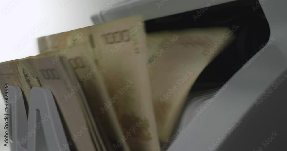Slow motion shot of an electronic cash counting machine, 1,000 baht bills, operating capital
