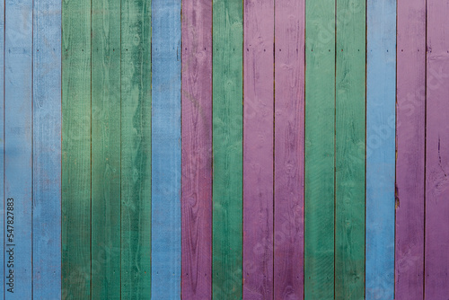 Colorful wooden painted bars. Texture of painted purple, blue, green wood boards vertical orientation. Painted wood background