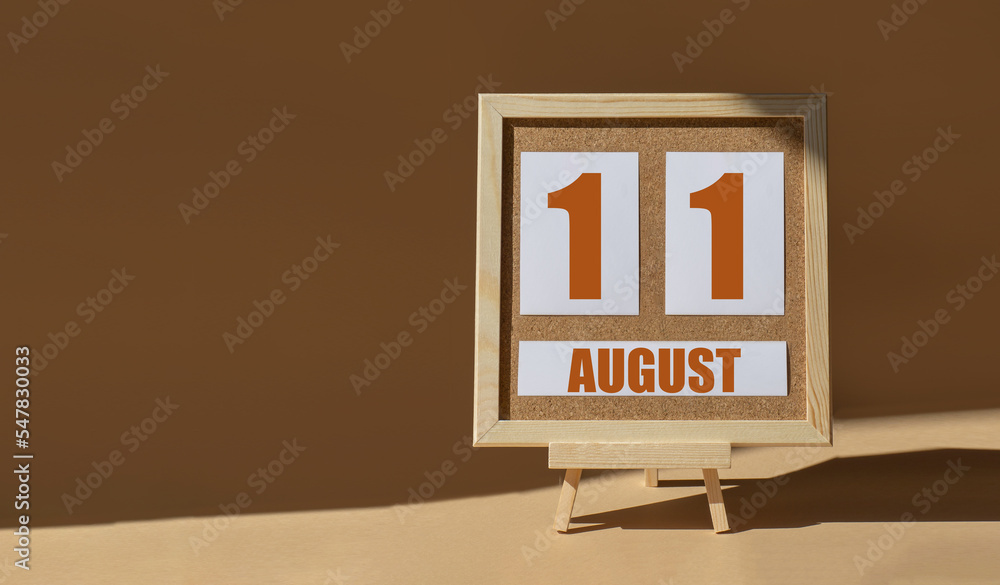 August 11th. Day 11 of month, Calendar date. Cork board, easel in sunlight on desktop. Close-up, brown background. Summer month, day of year concept August 11th. Day 11 of month, Calendar date. Cork board, easel in sunlight on desktop. Close-up, brown background. Summer month, day of year concept