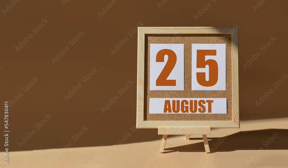 August 25th. Day 25 of month, Calendar date. Cork board, easel in sunlight on desktop. Close-up, brown background. Summer month, day of year concept August 25th. Day 25 of month, Calendar date. Cork board, easel in sunlight on desktop. Close-up, brown background. Summer month, day of year concept