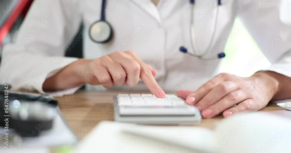 Doctor hand used calculator for medical expenses Doctor hand used calculator for medical expenses