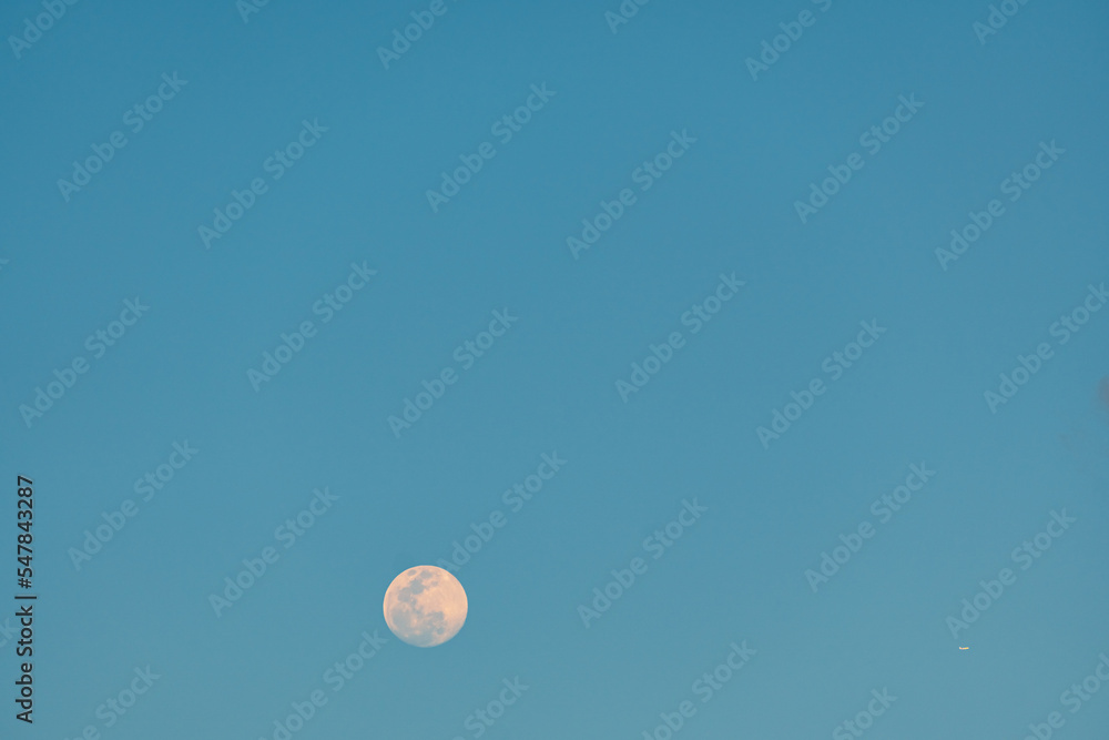 Full moon and airplane in the blue sky Full moon and airplane in the blue sky