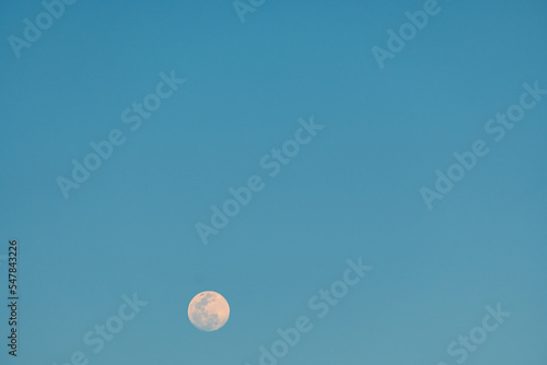 Full moon and airplane in the blue sky