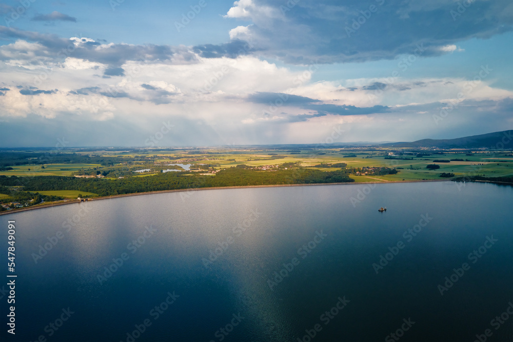 Aerial top view of beautiful landscape with large lake against mountains shapes at summer day. Mietkow lake near Wroclaw, Poland