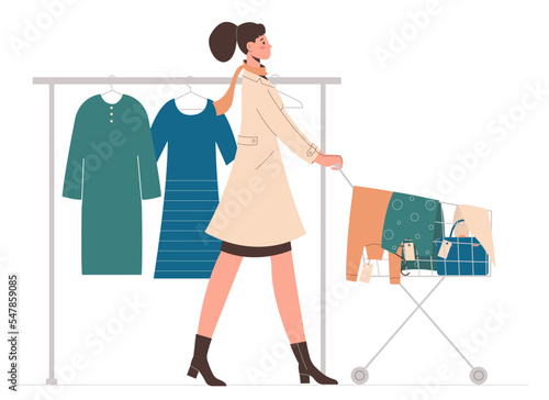 Young woman pushes cart full of goods. Sale, fashion, shopaholic concept.