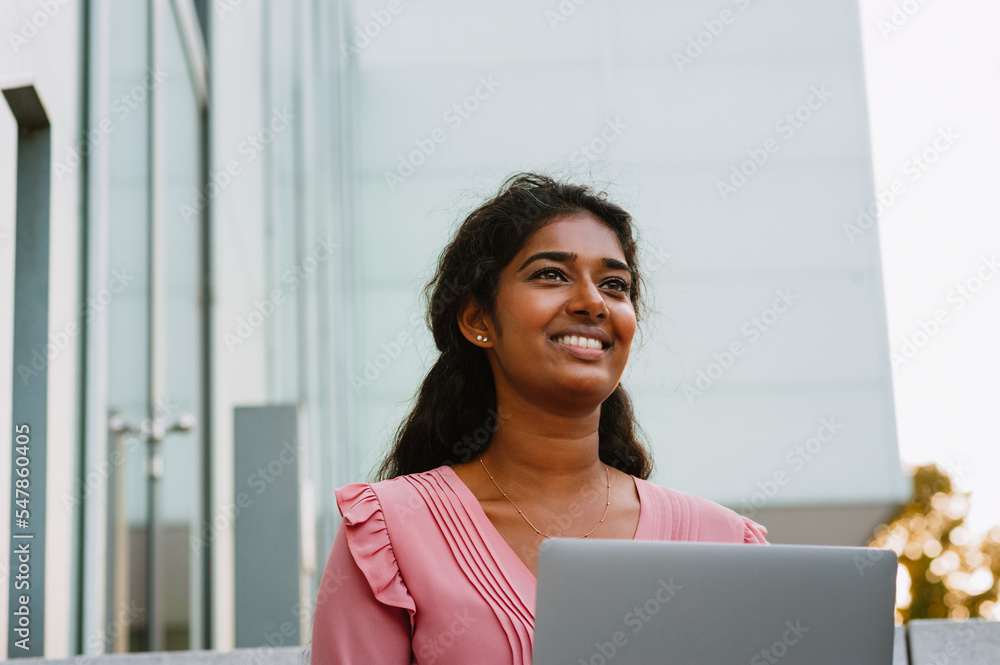 Middle-eastern women using laptop while sitting on stairs outdoors Middle-eastern women using laptop while sitting on stairs outdoors