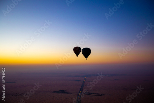 Heißluftballon Fahrt zum Sonnenaufgang am Horizont über der Wüste Dubai