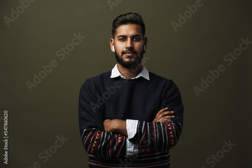 Portrait of man with folded hands with wireless earphones isolated